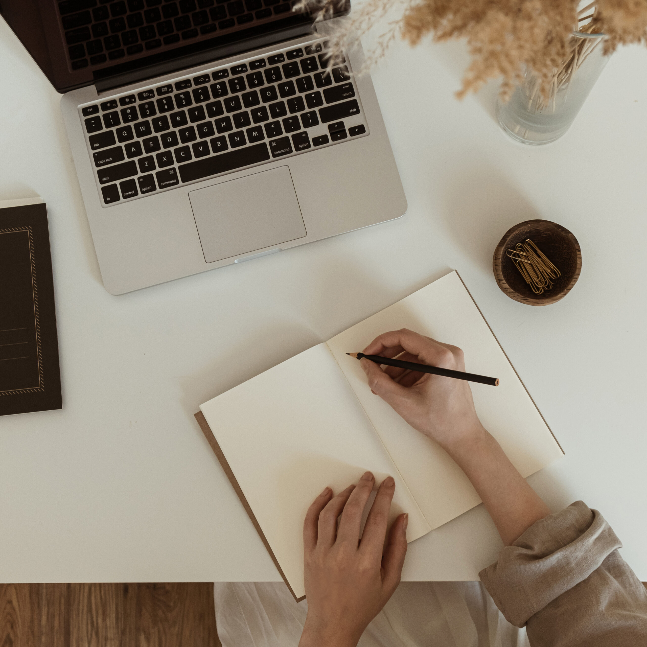 flatlay-women-s-hands-writing-notebook-sheet-comfortable-home-office-workspace-interior-design